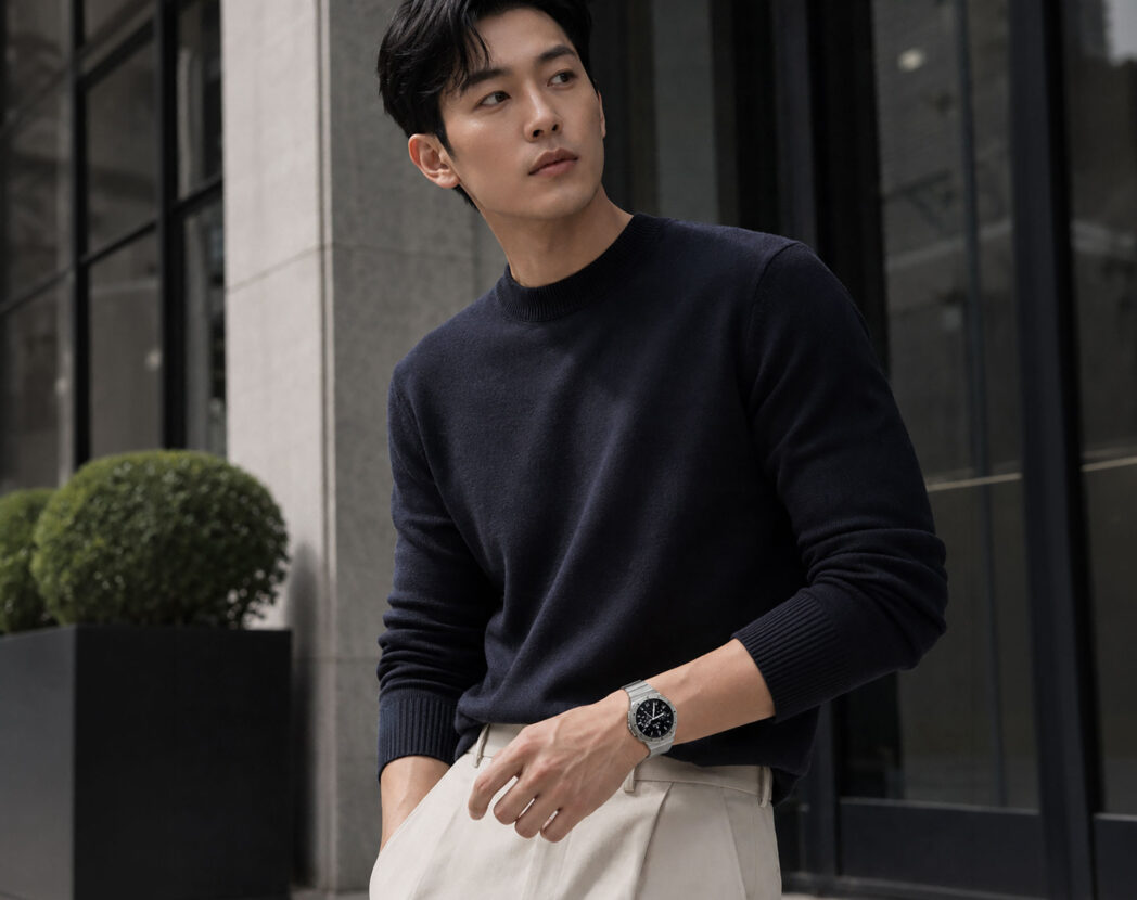 네이비 니트와 베이지 팬츠에 N42 링크 브레이슬릿 스트랩을 착용한 남성
