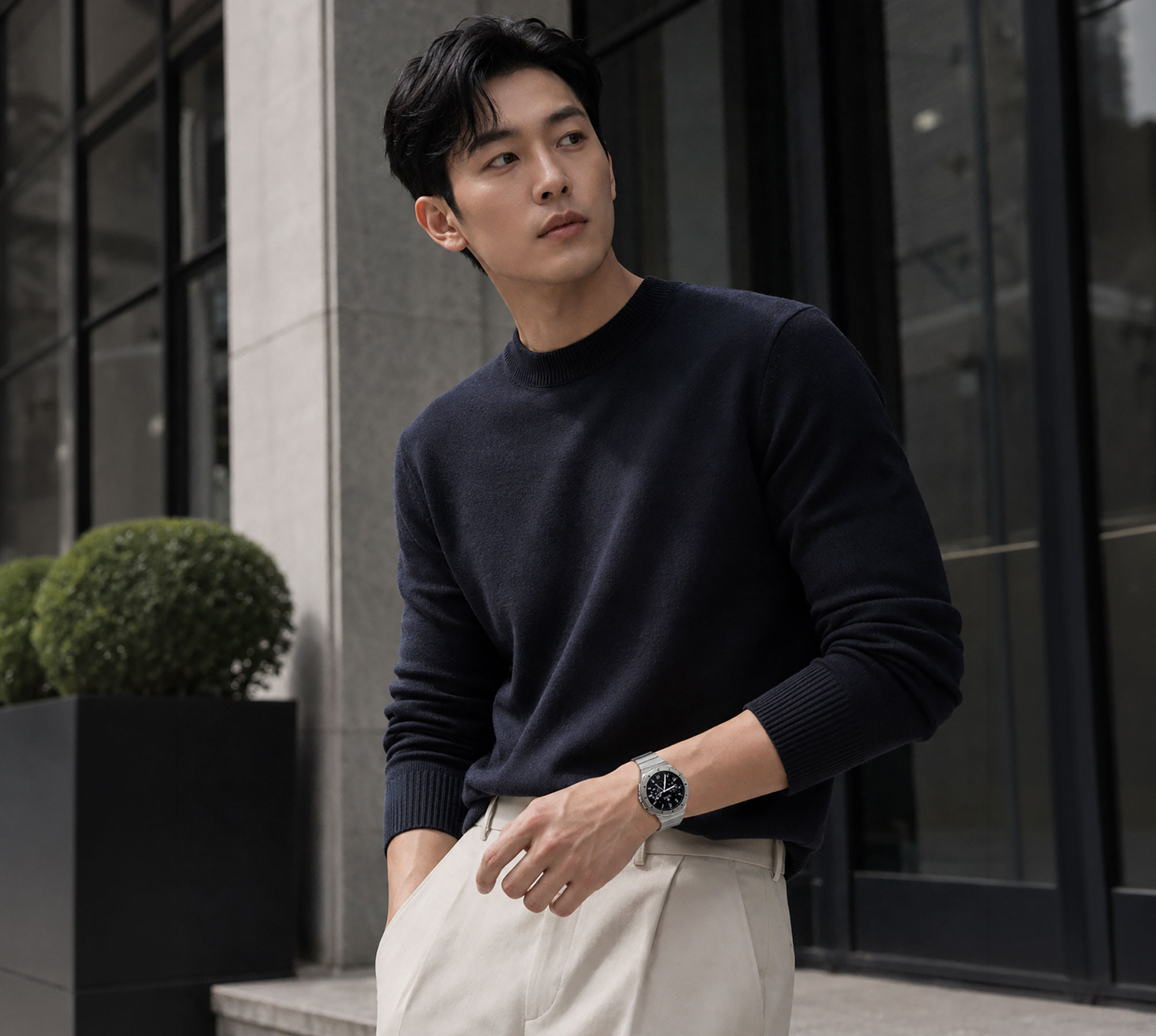 네이비 니트와 베이지 팬츠에 N42 링크 브레이슬릿 스트랩을 착용한 남성